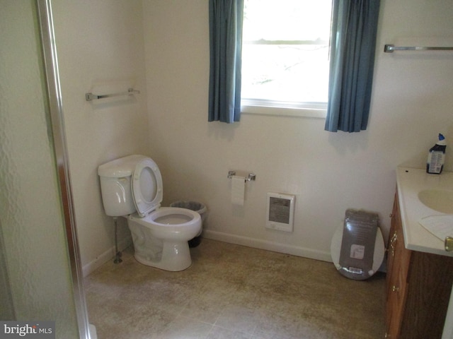 bathroom featuring vanity, heating unit, and toilet