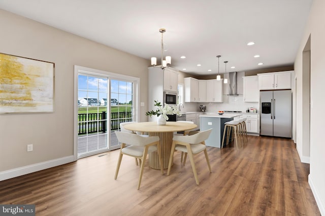 dining room with visible vents, wood finished floors, recessed lighting, an inviting chandelier, and baseboards