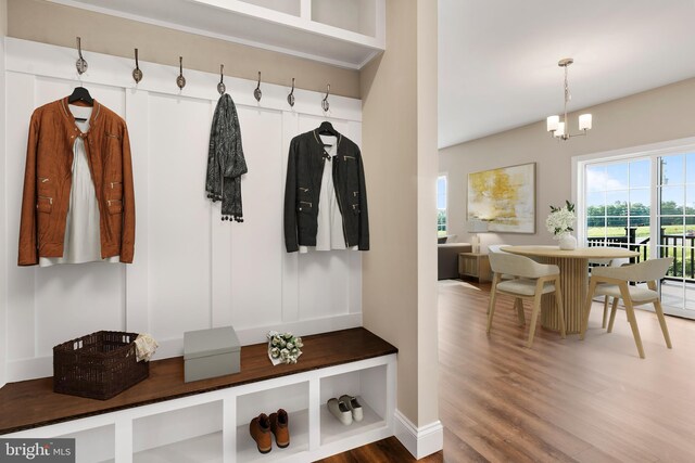 mudroom featuring a chandelier and wood finished floors