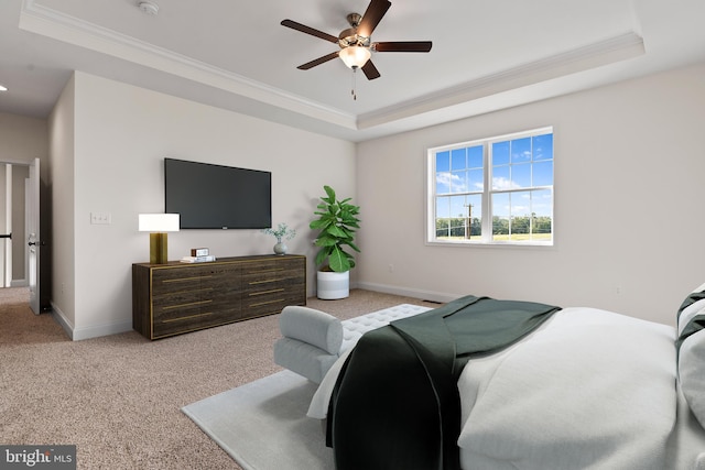 carpeted bedroom featuring crown molding, a tray ceiling, and ceiling fan