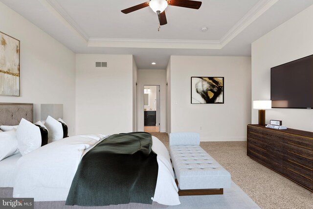 carpeted bedroom with ornamental molding, ceiling fan, a raised ceiling, and ensuite bathroom