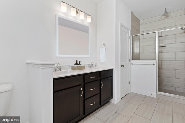 bathroom with walk in shower, vanity, and toilet