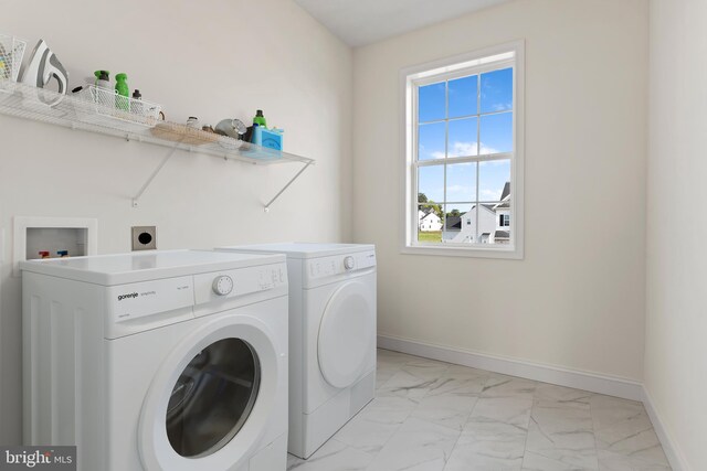 laundry area with baseboards, separate washer and dryer, marble finish floor, and laundry area