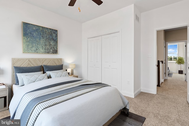 carpeted bedroom with ceiling fan and a closet