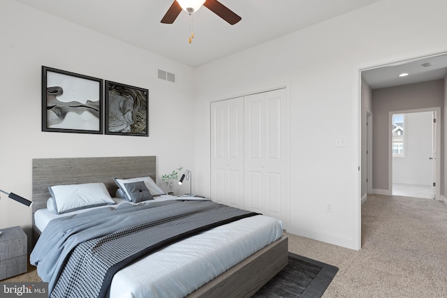 carpeted bedroom with a ceiling fan, baseboards, visible vents, and a closet