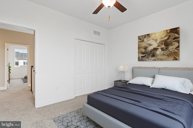 bedroom with ceiling fan, a closet, and light carpet