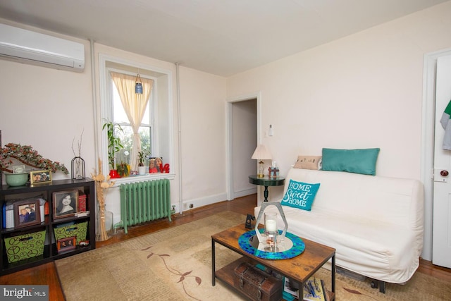 sitting room featuring wood-type flooring, radiator, and an AC wall unit