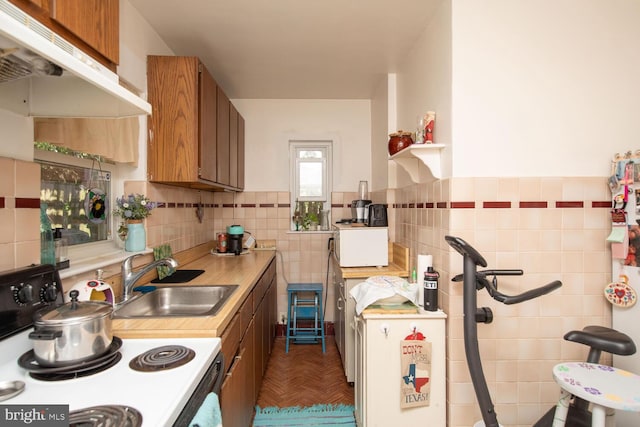 kitchen with sink, tile walls, and white electric stove