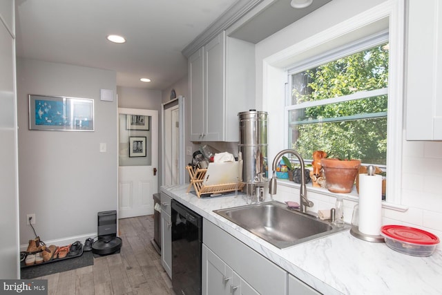 kitchen featuring backsplash, black dishwasher, gray cabinets, hardwood / wood-style floors, and sink