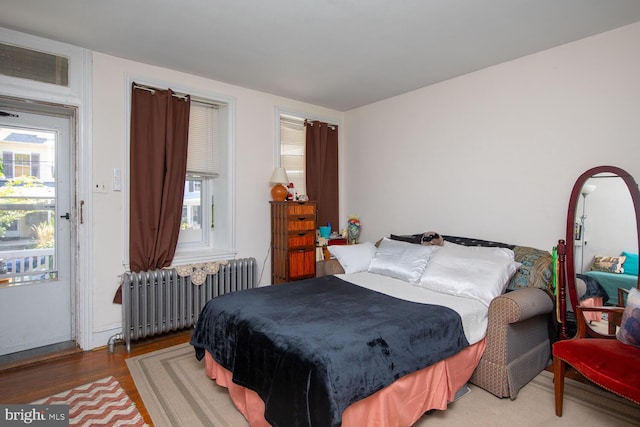 bedroom with hardwood / wood-style floors and radiator heating unit