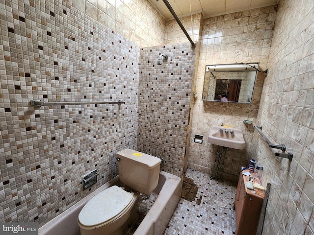 full bathroom with tiled shower / bath, sink, tile walls, and toilet