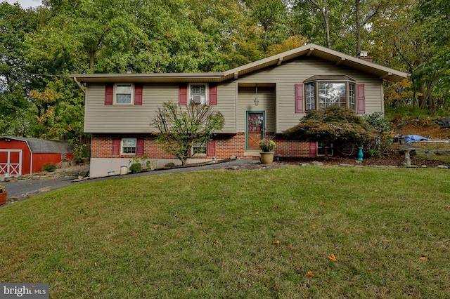 split foyer home featuring a front yard and a storage unit