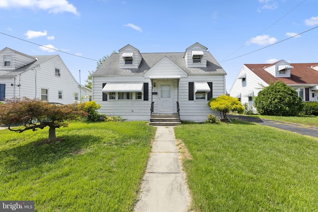 cape cod house featuring a front yard