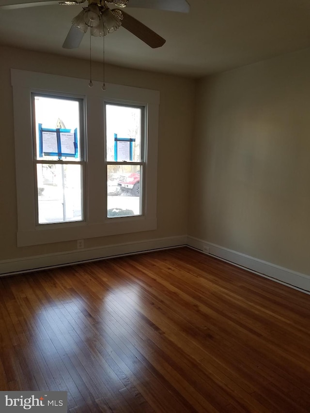 empty room with dark hardwood / wood-style floors and ceiling fan