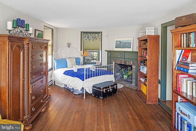 bedroom with dark wood-type flooring and a fireplace