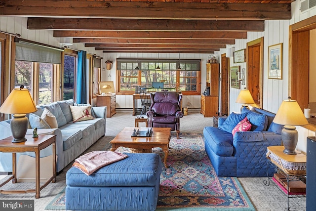 living room with beam ceiling, wood walls, and carpet flooring