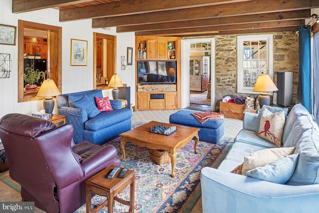 carpeted living room featuring beamed ceiling