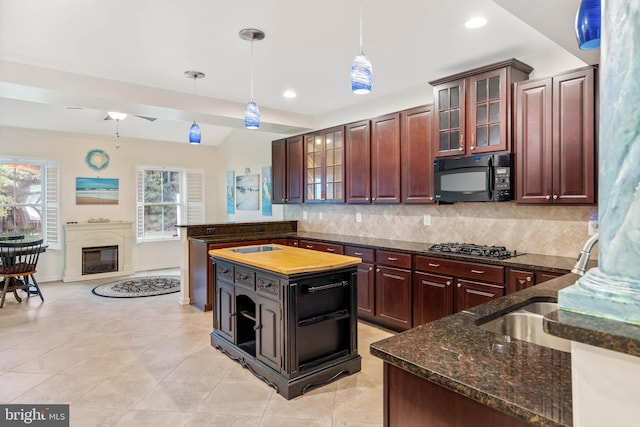 kitchen with black appliances, a center island, hanging light fixtures, and tasteful backsplash