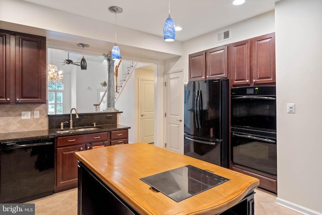 kitchen featuring decorative backsplash, pendant lighting, black appliances, sink, and a chandelier