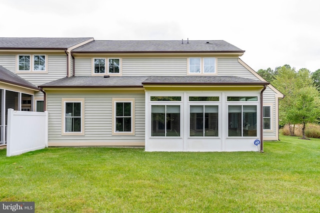 rear view of house with a yard and a sunroom