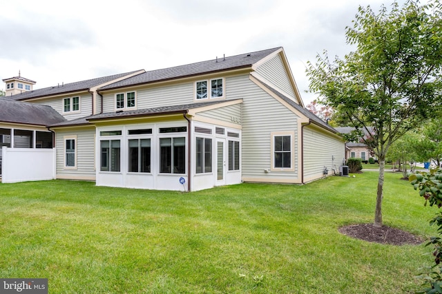 rear view of house with a sunroom, cooling unit, and a yard