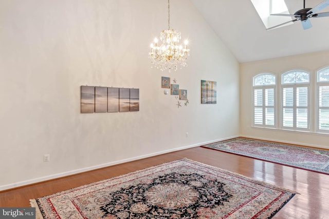 interior space with ceiling fan with notable chandelier, wood-type flooring, and high vaulted ceiling