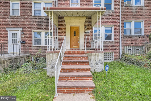 view of exterior entry featuring a lawn