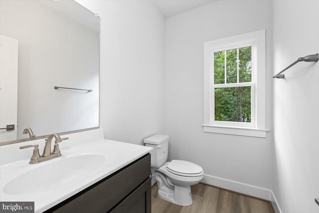 bathroom with hardwood / wood-style floors, vanity, and toilet