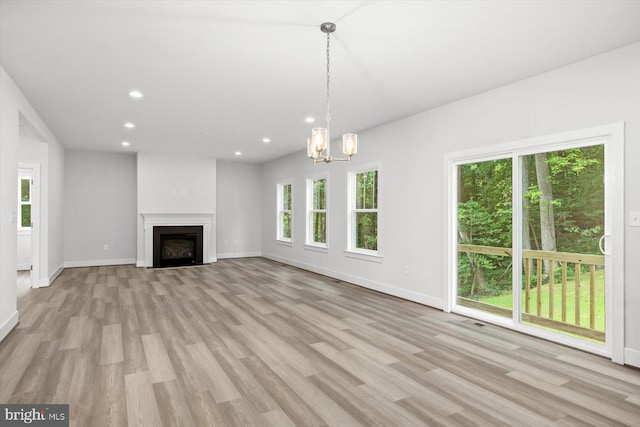 unfurnished living room featuring light hardwood / wood-style floors and a chandelier