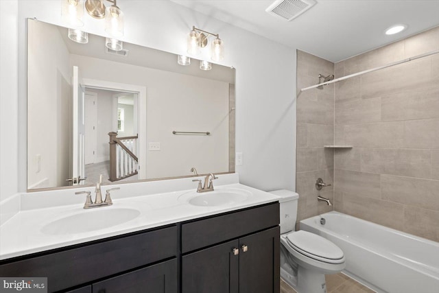 full bathroom with tiled shower / bath combo, vanity, and toilet