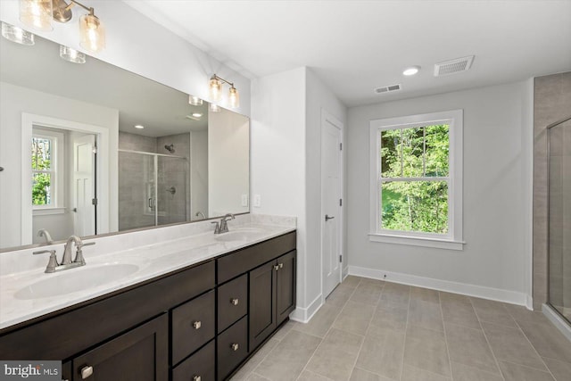 bathroom featuring tile patterned flooring, an enclosed shower, and vanity