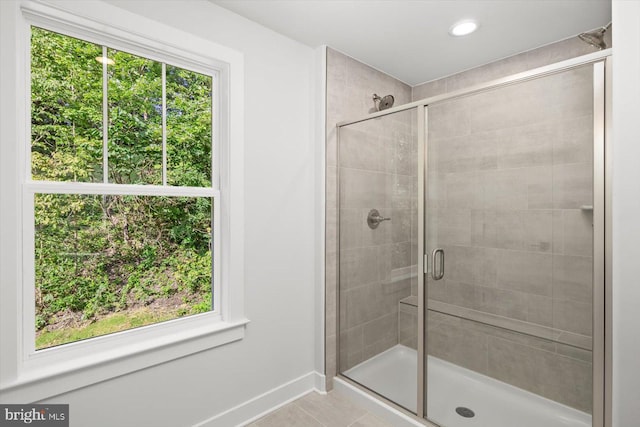 bathroom featuring tile patterned floors, an enclosed shower, and a healthy amount of sunlight