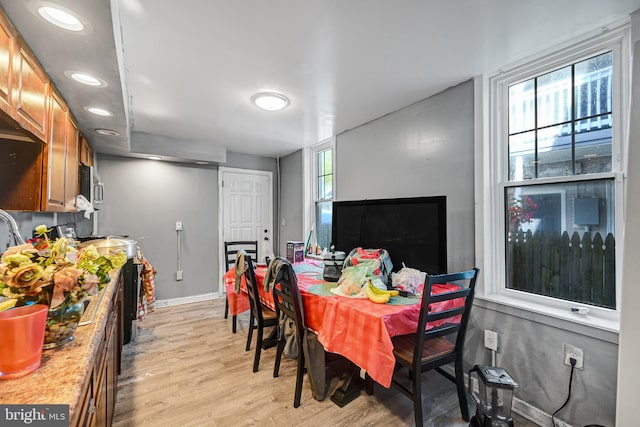 dining space with light wood-type flooring and a wealth of natural light