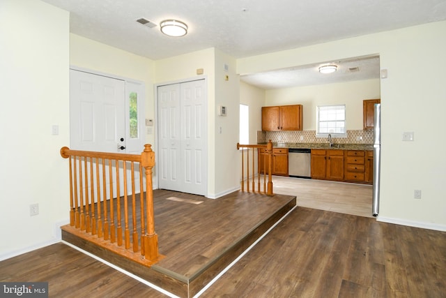 entryway with a textured ceiling, hardwood / wood-style floors, and sink