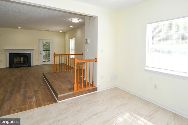 interior space with a textured ceiling and hardwood / wood-style flooring