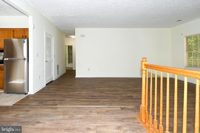 interior space with a textured ceiling and dark wood-type flooring