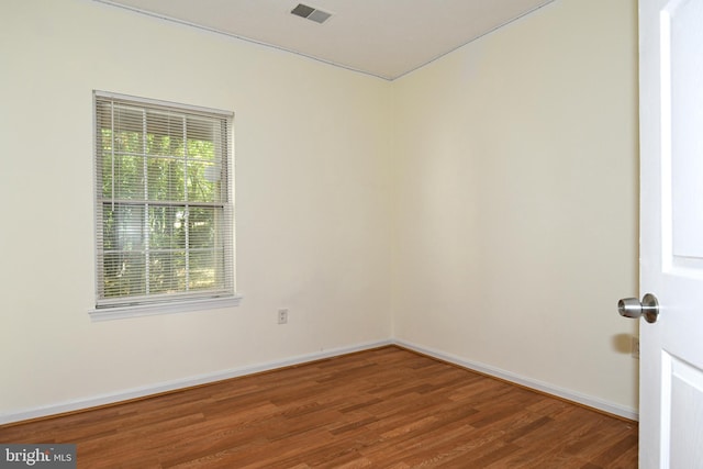 spare room featuring hardwood / wood-style flooring and plenty of natural light