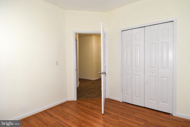 unfurnished bedroom featuring a closet and hardwood / wood-style flooring