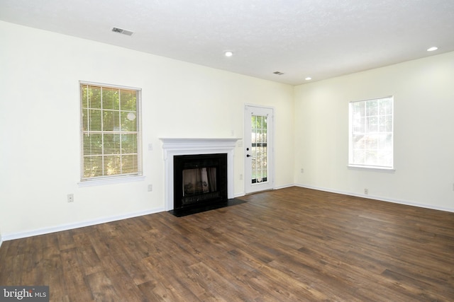 unfurnished living room featuring a textured ceiling and dark hardwood / wood-style flooring