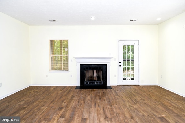 unfurnished living room featuring dark hardwood / wood-style flooring and plenty of natural light