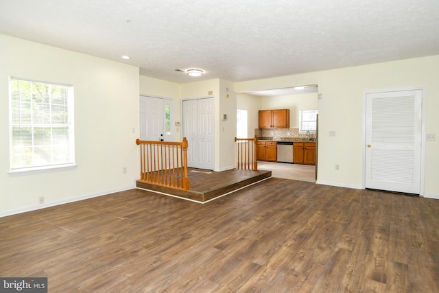 unfurnished living room with sink, dark hardwood / wood-style flooring, and a textured ceiling