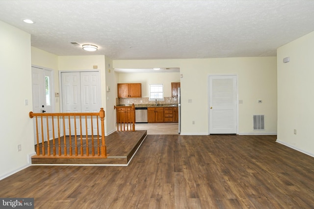 living room featuring a textured ceiling, sink, and dark hardwood / wood-style flooring