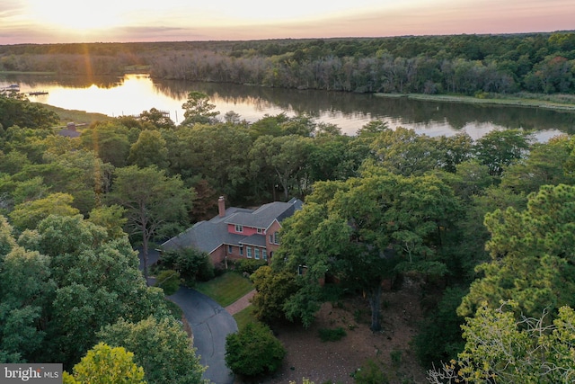 aerial view at dusk featuring a water view