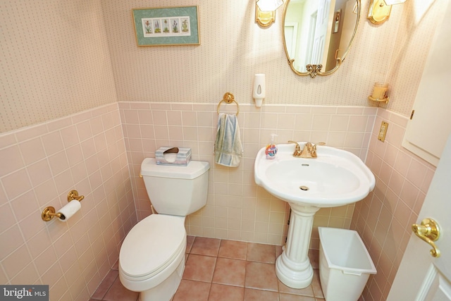 bathroom with tile walls, toilet, and tile patterned floors