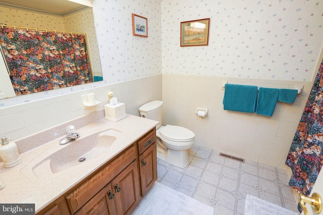 bathroom featuring tile walls, curtained shower, vanity, and toilet