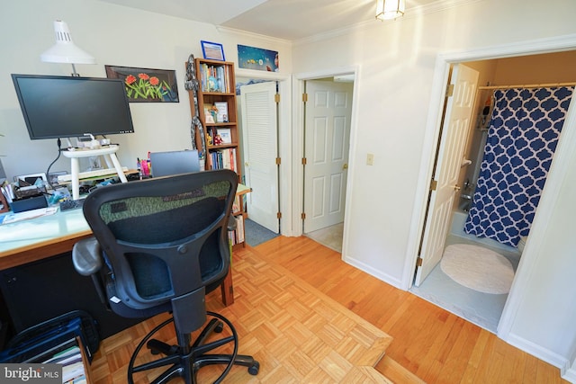 office with ornamental molding and light hardwood / wood-style flooring