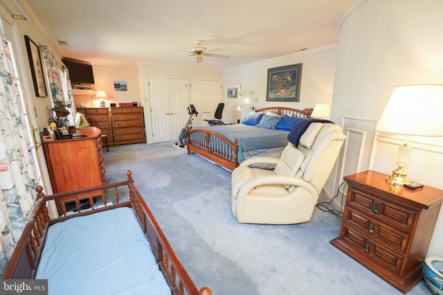 bedroom with a closet, light colored carpet, ceiling fan, and crown molding