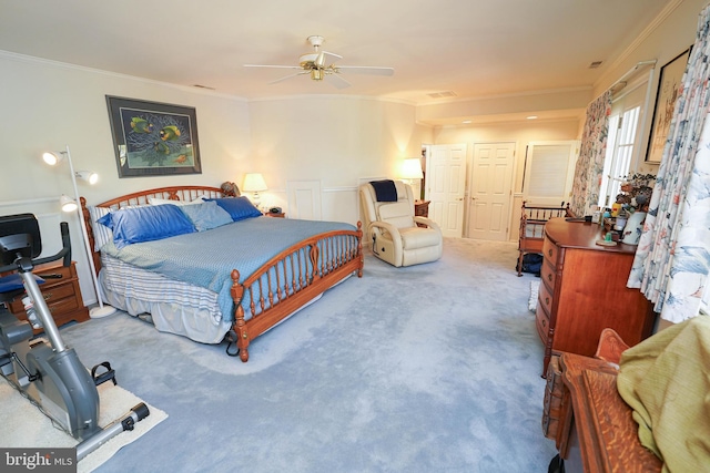 carpeted bedroom featuring ceiling fan and crown molding