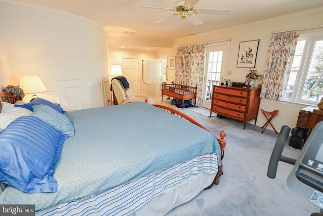 carpeted bedroom featuring ceiling fan and crown molding