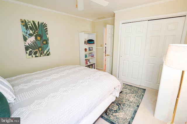 carpeted bedroom with ceiling fan, crown molding, and a closet